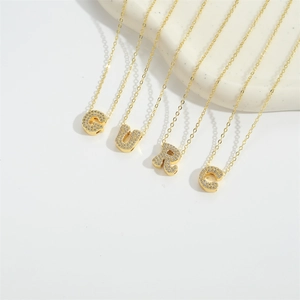 Gold plated initial necklaces with sparkling cubic zirconia charms G U R C