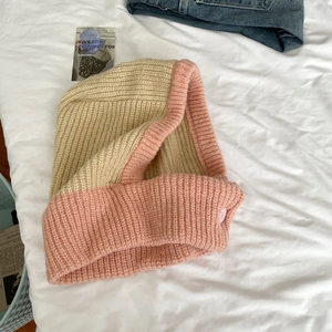 Detailed knit texture and button closure on pink and beige balaclava hood scarf