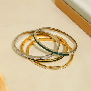 Gold and silver stainless steel bangles with white zircon and green gemstone inlays