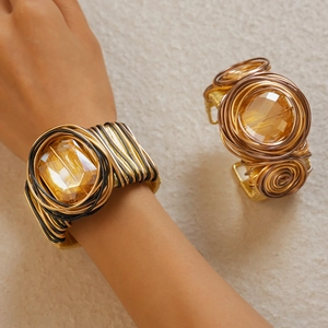 Detail of woven wire bracelet with large amber crystal in gold and bronze metal