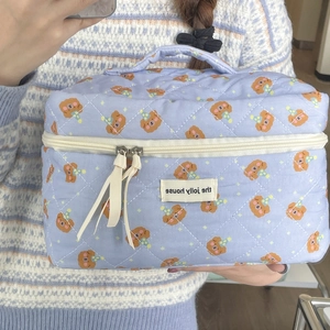 Detail of lavender quilted cosmetic bag with cute bear pattern and top handle