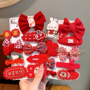 Detail of red festive hair clip set with velvet bows, knitted rabbit, and embroidery