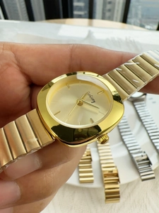 Close-up of minimalist gold women's watch featuring a rectangular case and metal chain strap