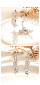 Detail of silver star and moon earrings with blue zircon and elegant leaf props