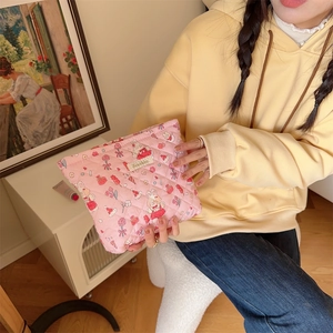 Pink quilted makeup bag with cartoon rabbits and strawberries held by hand in a cozy room