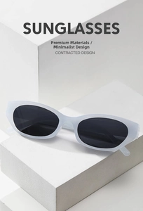 Close-up of matte white sunglasses with dark lenses on a minimalist geometric block