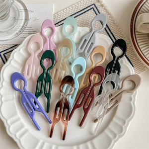 Minimalist U-shaped fish hair fork set in assorted colors on a decorative tray