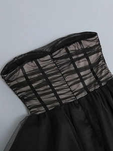 Detailed view of layered mesh fabric and corset-style boning on black bustier dress