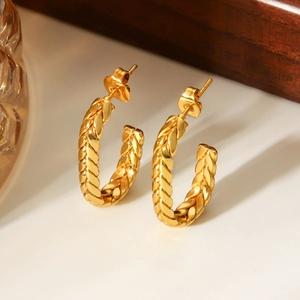 Close-up of gold-plated stainless steel twisted hoop earrings with woven texture detail