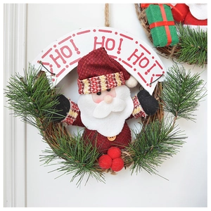Detail of Santa Claus plush doll on pine needle Christmas wreath with Ho Ho Ho banner