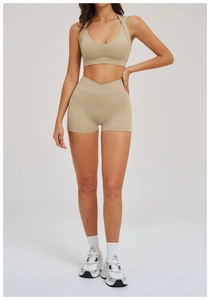 Detail shot of beige high-waist yoga shorts with a cross-over waistband and matching top