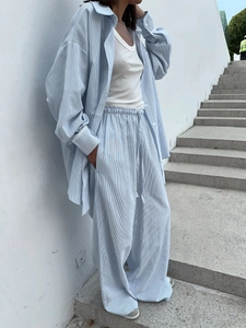 Detail of blue striped linen shirt and matching wide-leg trousers set with drawstring waist