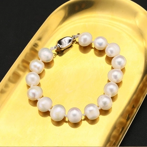 Detailed view of white natural pearls in a golden tray with an elegant metal clasp