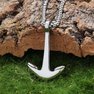 Nautical anchor pendant with silver bead chain placed on rustic bark and green moss