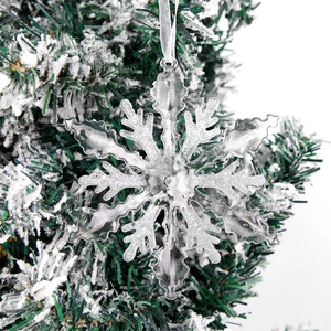 Transparent 13cm acrylic snowflake ornament hanging on a snowy Christmas tree branch