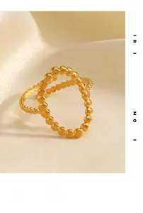 Dettaglio dell'anello a doppia fascia con sfere placcato oro 18K su raso morbido