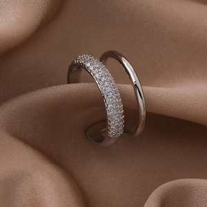 Detail of double-layer silver ring with pave-set zircons on elegant brown satin fabric