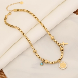 Detail of gold chain necklace with cross, coin pendant, and turquoise stone bead