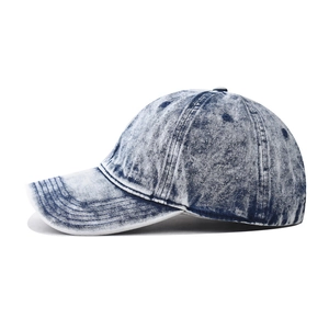 Detail of stonewashed navy denim baseball cap showing retro vintage texture and stitching