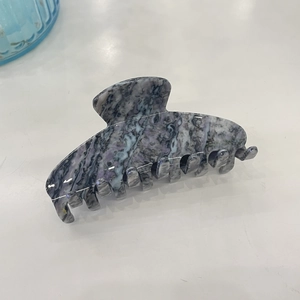 Macro view of acetate hair claw clip with purple and grey marble texture finish