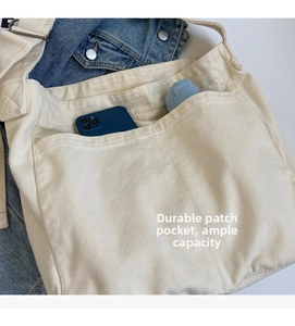 Close-up of large canvas bag pocket holding a smartphone and a folding umbrella