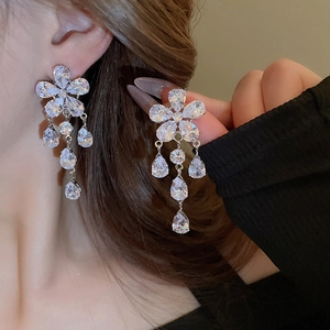Macro detail of silver flower earrings with sparkling cubic zirconia teardrop tassels
