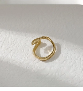 Macro shot of minimalist gold open ring with irregular lava texture and vintage style