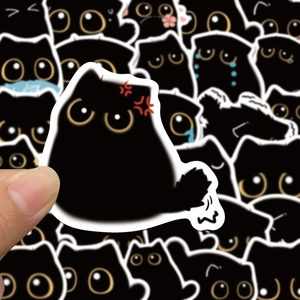 Close-up of cute black soot cat stickers being held showing high printing quality
