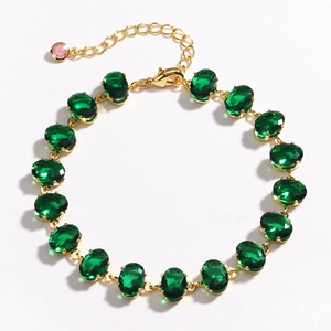 Detailed view of a gold chain bracelet featuring sixteen oval green zircon gemstones
