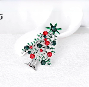 Close-up of sparkling Christmas tree brooch with festive red and green rhinestones