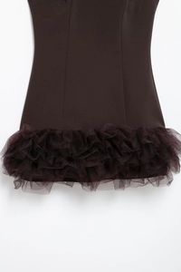 Detail of layered brown mesh ruffles on the hem of a sleeveless bodycon mini dress