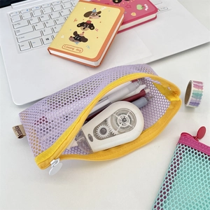 Detail view of purple nylon mesh pencil case with yellow zipper showing stationery storage