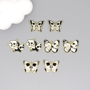 Detailed view of eight black and white skull butterfly alloy pendants for DIY jewelry
