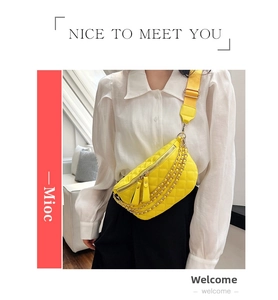 Detail of bright yellow quilted chest bag with gold chain and wide shoulder strap