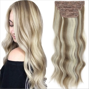 Detail of 4-piece clip-in hair extensions showing golden brown ombre texture and clips