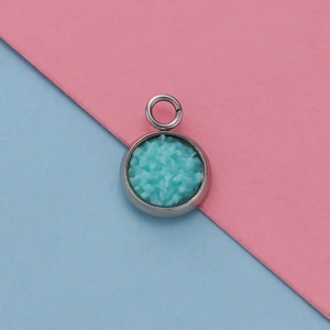 Top view of 12mm stainless steel pendant tray with sky blue resin inlay on pink blue background