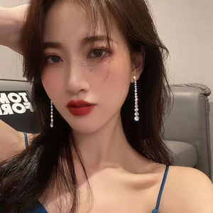 Close-up of sparkling long tassel rhinestone earrings on a model for a stylish look