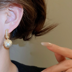 Detail of vintage gold plated lace earrings with white pearl and sparkling crystals