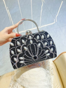 Detail of black rhinestone evening bag with pearl floral patterns and metal handle