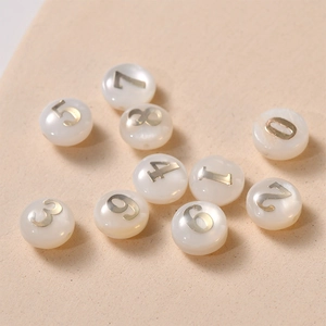 Macro shot of vintage round shell beads with gold numbers for DIY jewelry making