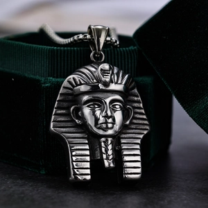 Macro detail of ancient Egyptian Pharaoh pendant on a dark green velvet jewelry box