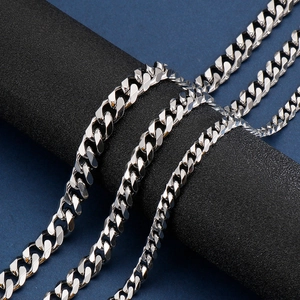 Close-up of silver Cuban link chains in three widths on a black display pillar
