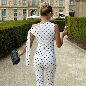 Detail eines weißen Ein-Schulter-Punkt-Tops und der passenden Hose an einer Frau