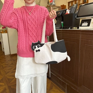 Detail of cute cat-themed canvas tote bag featuring black spots and bow design