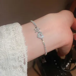 Elegant silver bracelet with zircon star and hollow heart charms on a lace cuff background