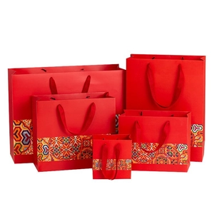 Chinese New Year red gift bags with traditional patterns and woven rope handles