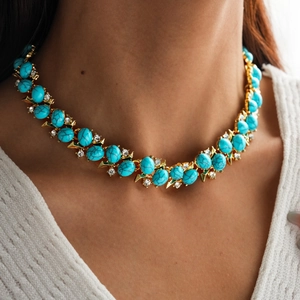 Detail of vintage gold necklace featuring turquoise stones and zircon crystal accents
