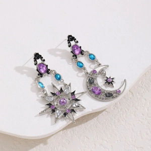Macro shot of vintage sun and moon asymmetric earrings with purple and blue gemstones