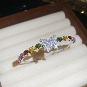 Dettaglio del bracciale aperto con farfalla in zircone e pietre colorate a goccia
