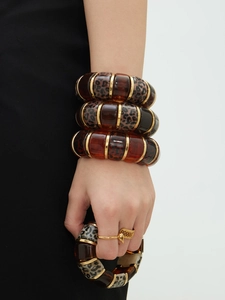Detail view of resin bangle set with leopard print and amber texture on a model hand